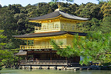 The Golden Pavilion is a building of three storeys with encircling balconies and curving roofs, overlooking a tranquil lake and woods