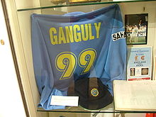 A blue colored t-shirt displayed at a store window. The t-shirt has the words